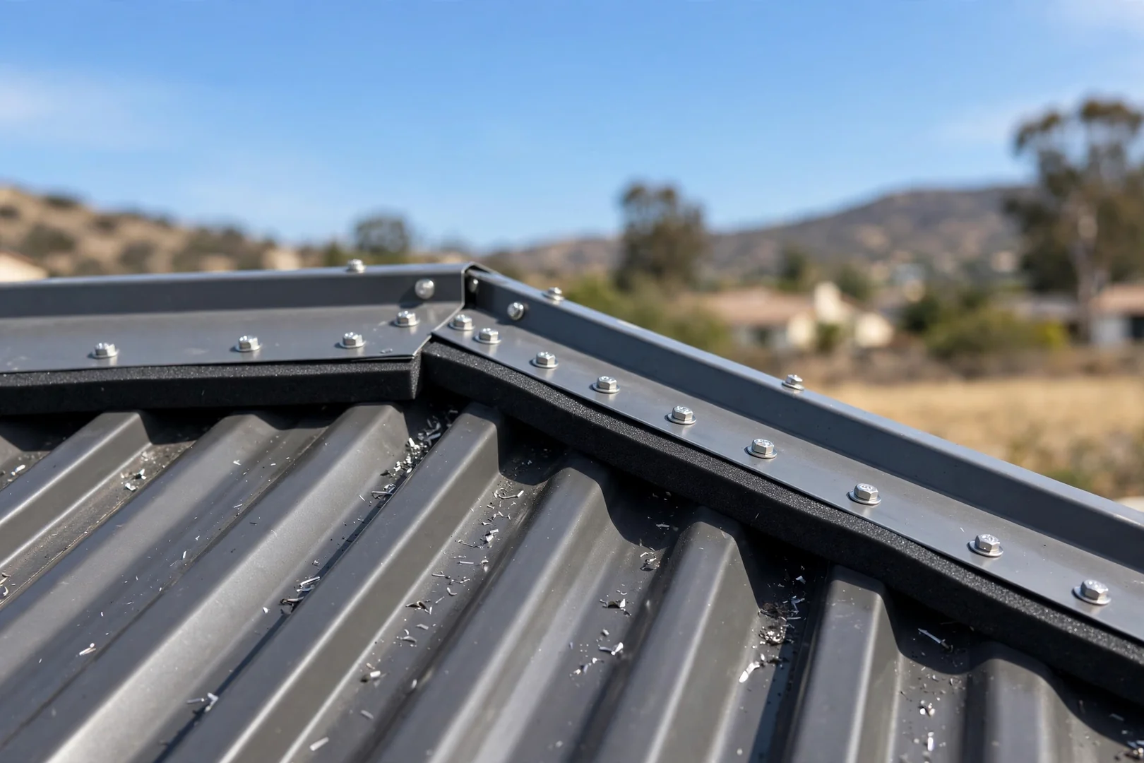 Ridge cap and closure strips completing a new residential metal roof assembly